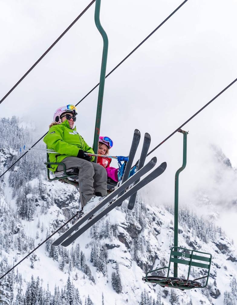 two children age three with instructors on magic carpet terrain