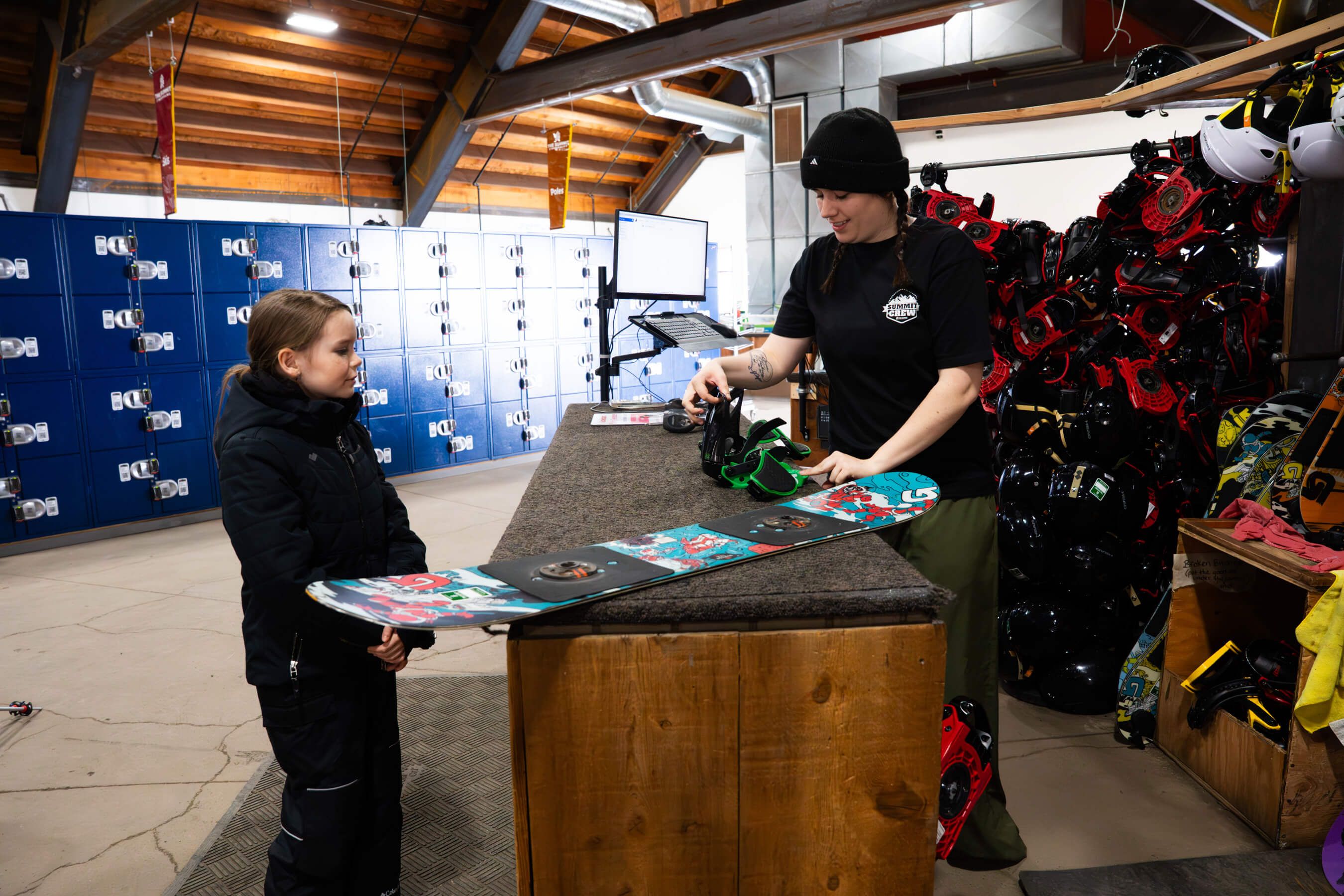 A child getting sized for a snowboard in the rental shop