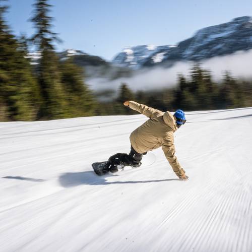 snowboarders carving turn