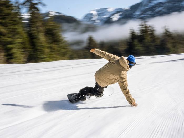 snowboarder carving on courderoy
