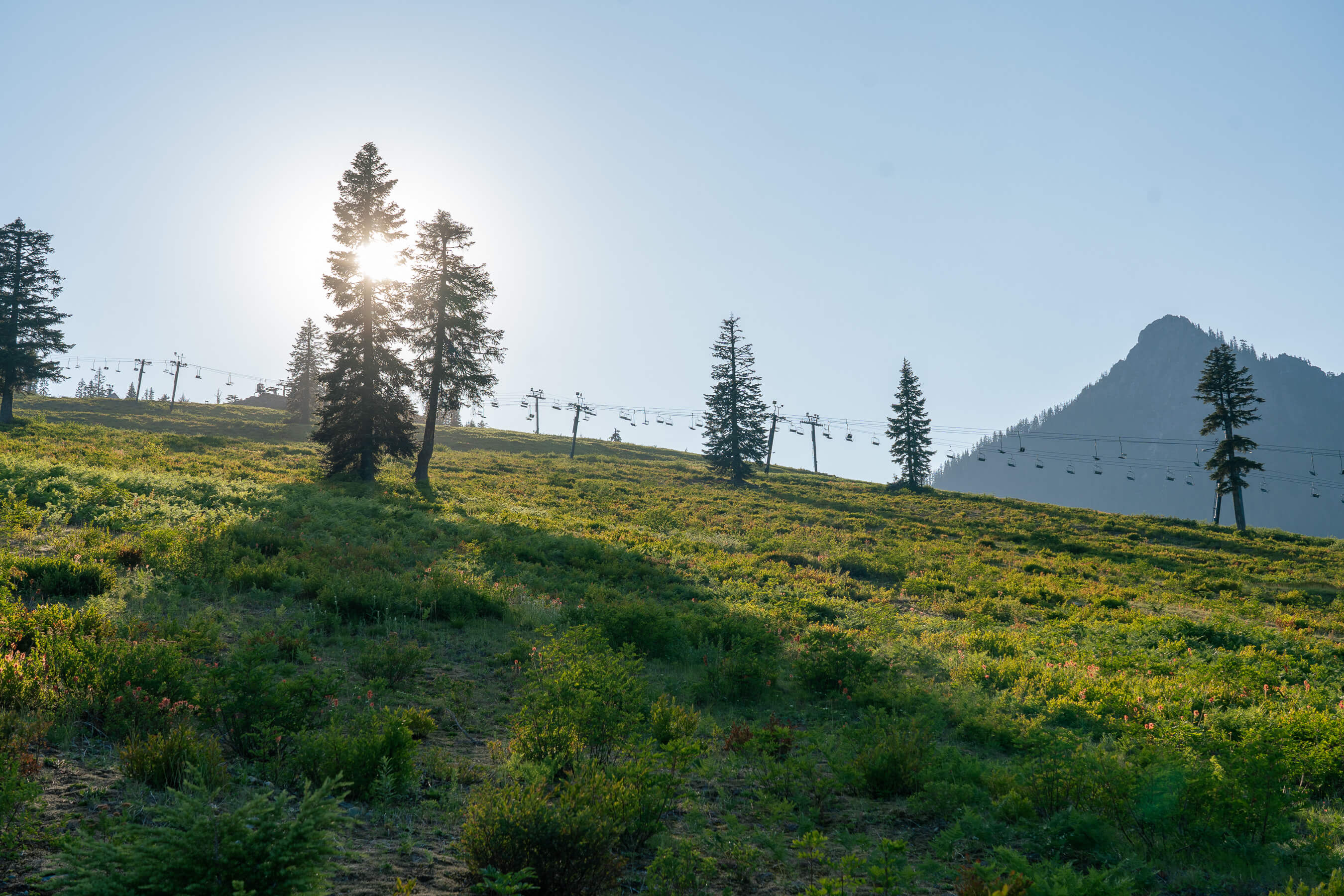 scenic image of sun slowly setting behind summit west with chairlifts in the background