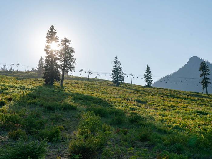 scenic image of sun slowly setting behind summit west with chairlifts in the background
