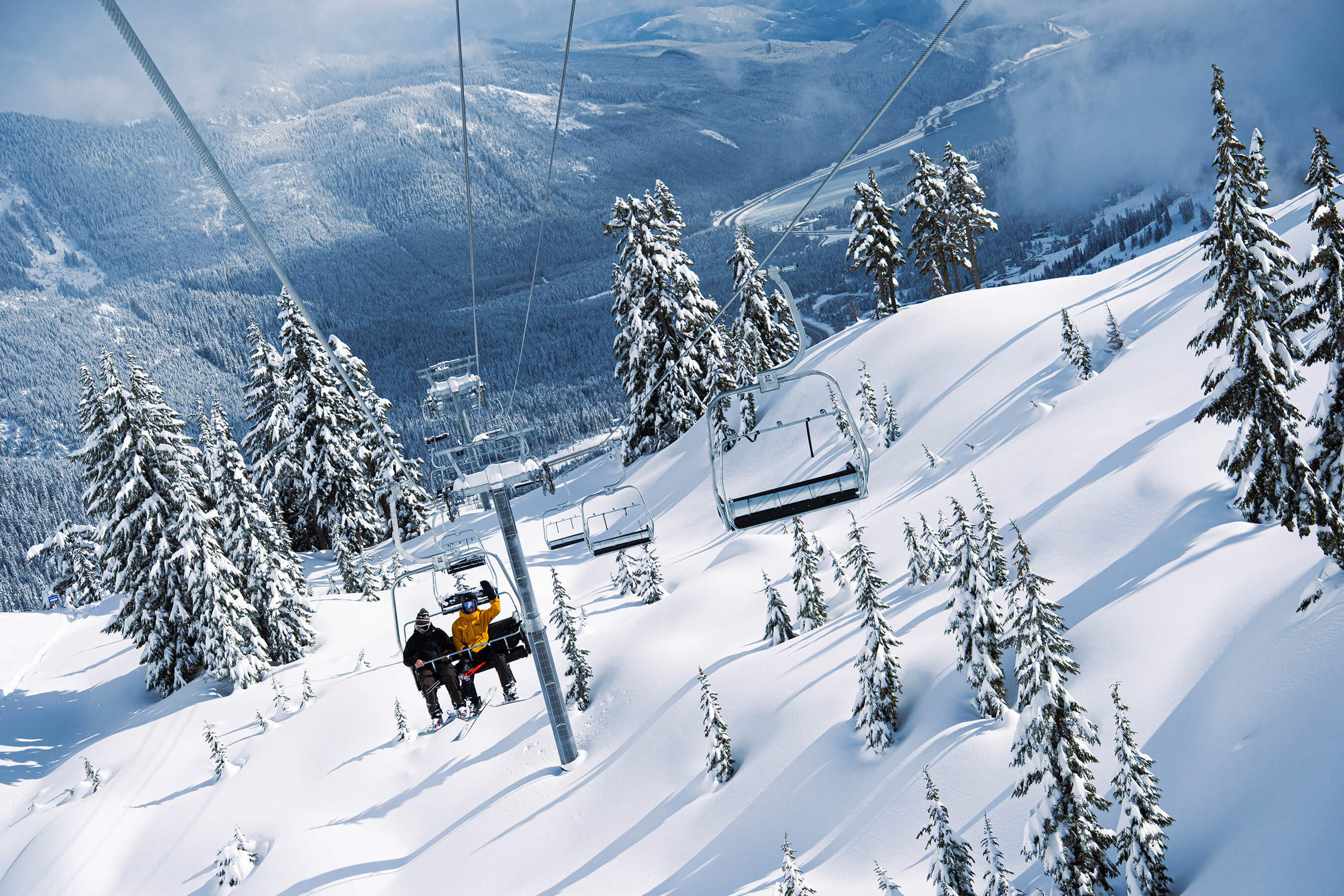 looking back at two people on edelweiss lift with the valley in the background