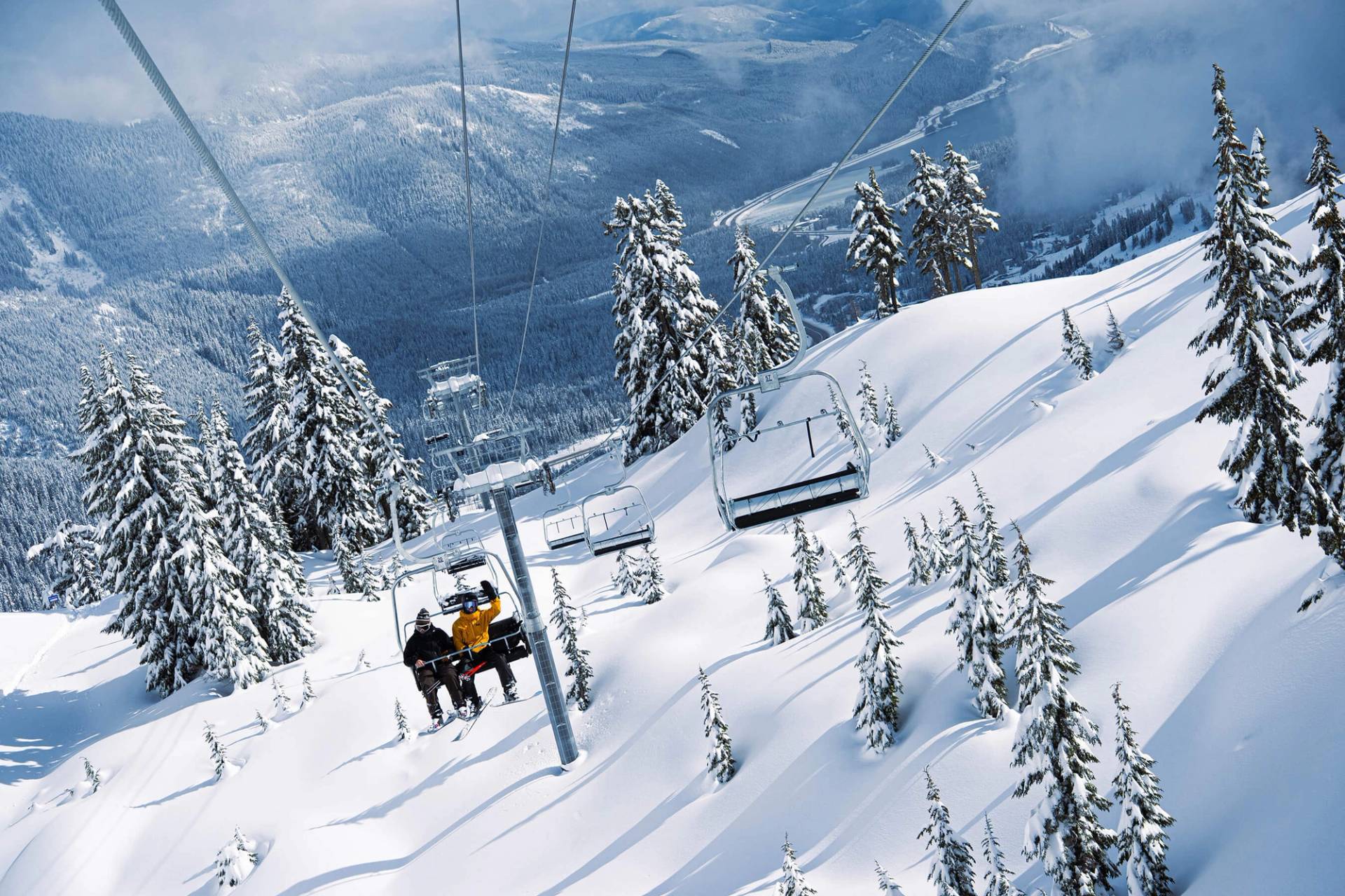 looking back at two people on edelweiss lift with the valley in the background