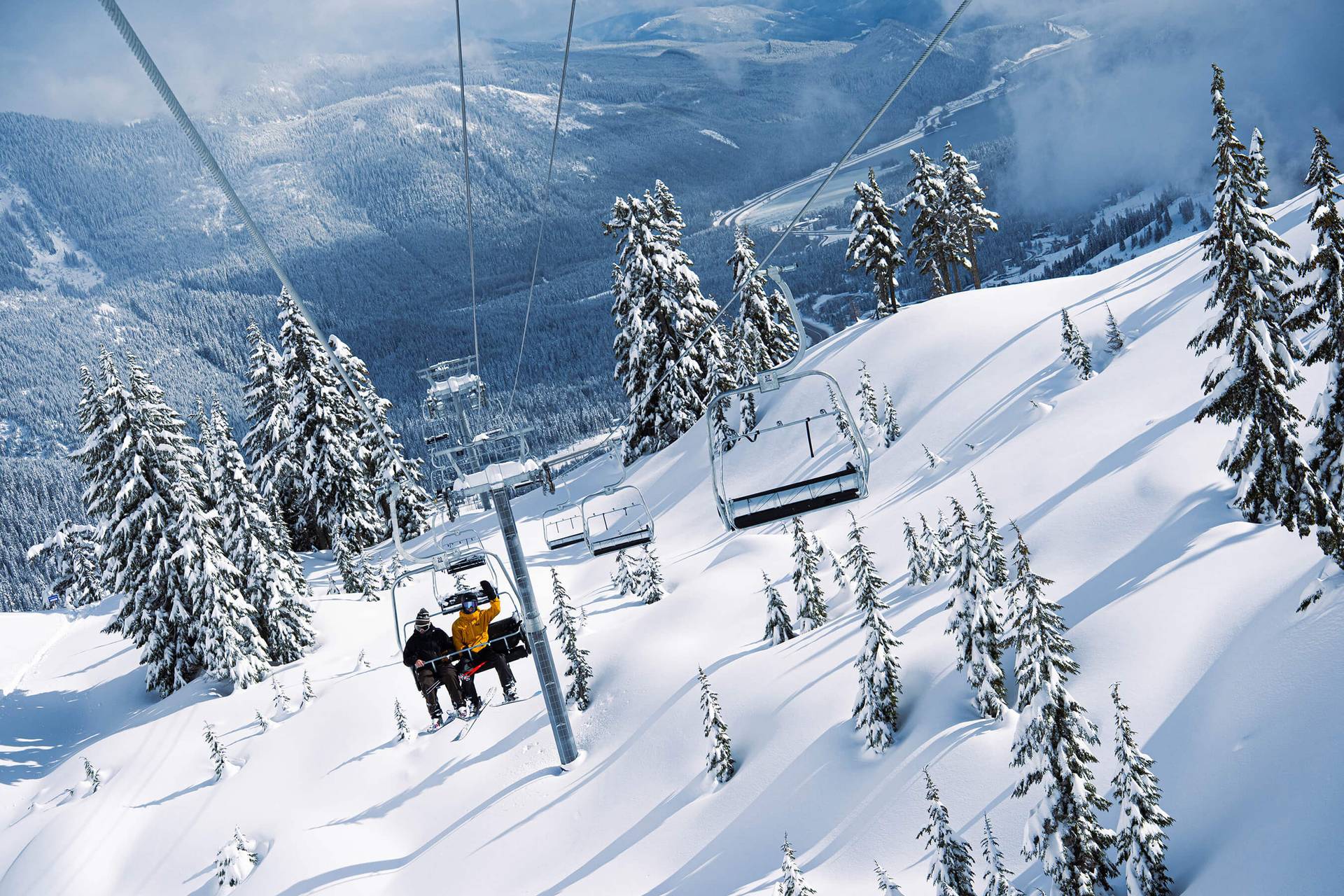 looking back at two people on edelweiss lift with the valley in the background