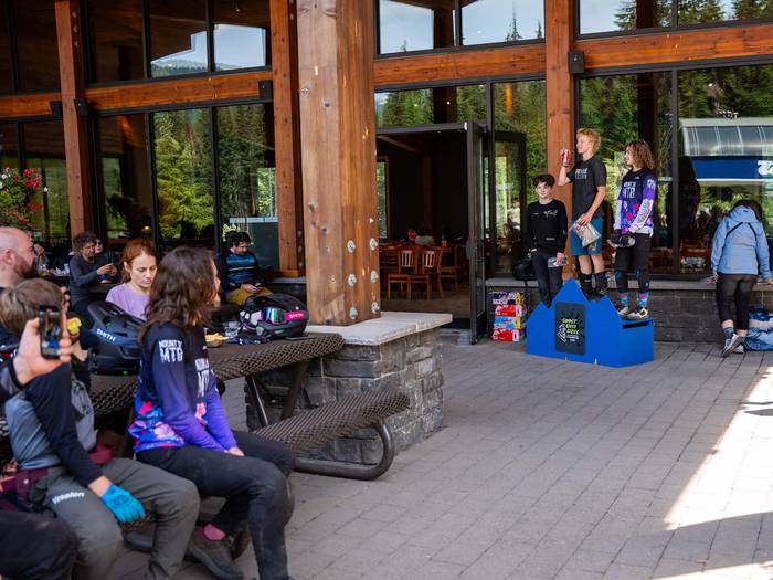 an audience watching kids line up on a podium with their prizes