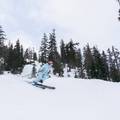 Woman in light blue jacket skis down slope as part of Rippin Chix event at Alpental