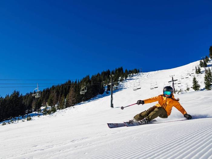 skier smiling groomer sunny day
