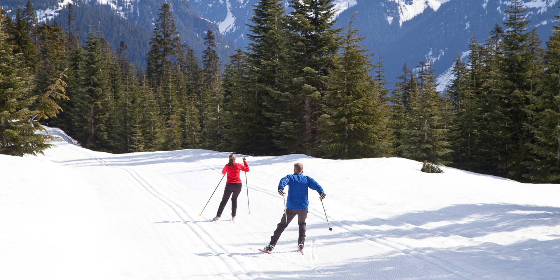 two people nordic skiing high in the mountains with views