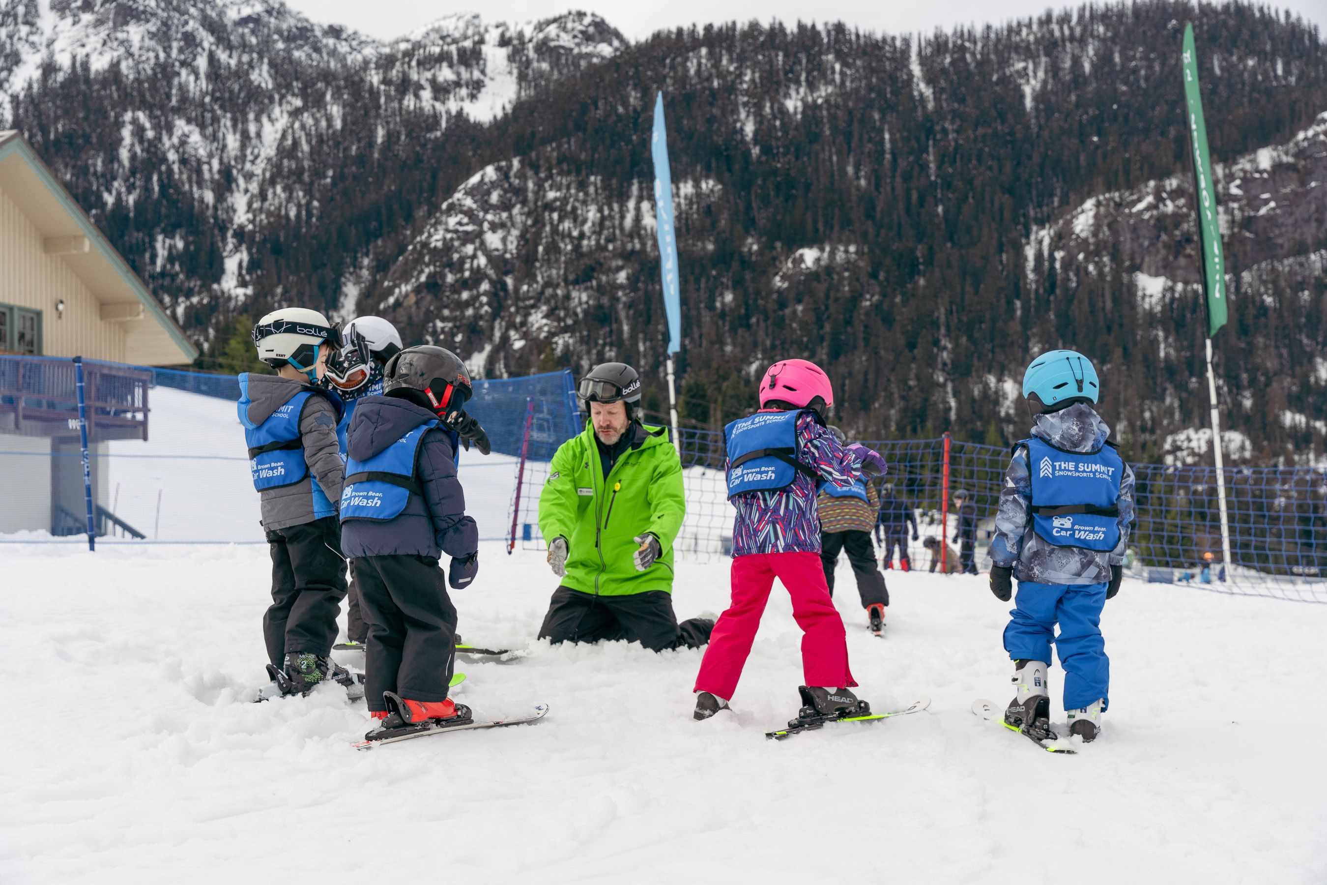 instructor kneeling in snow with group of lesson kids