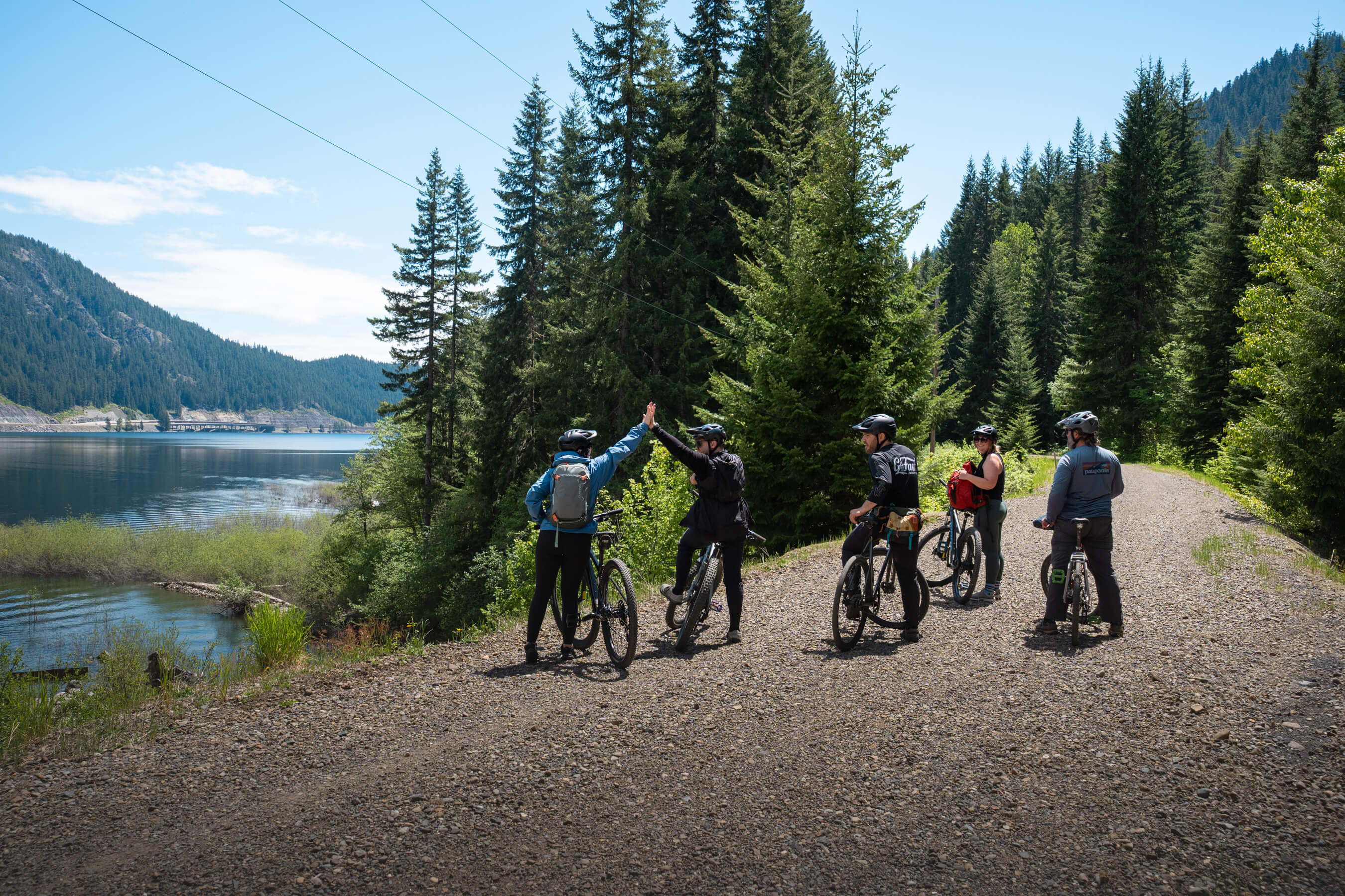 group of bikers celebrating their ride by the lake