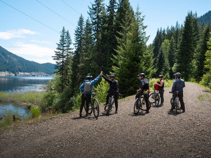 group of bikers celebrating their ride by the lake