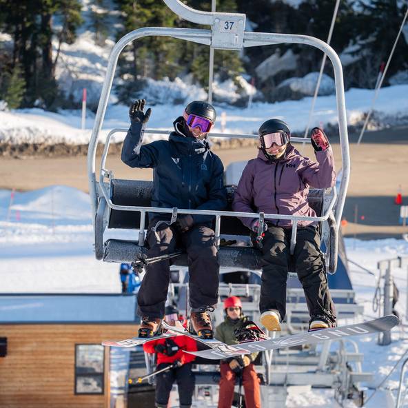 Two snowboarders on chairlift