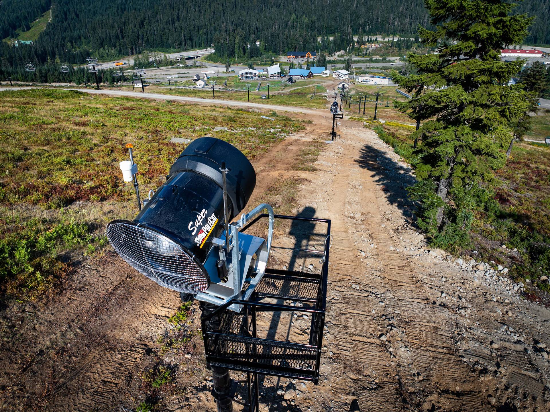 A view looking downhill at snow guns