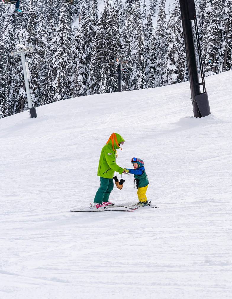 two children age three with instructors on magic carpet terrain
