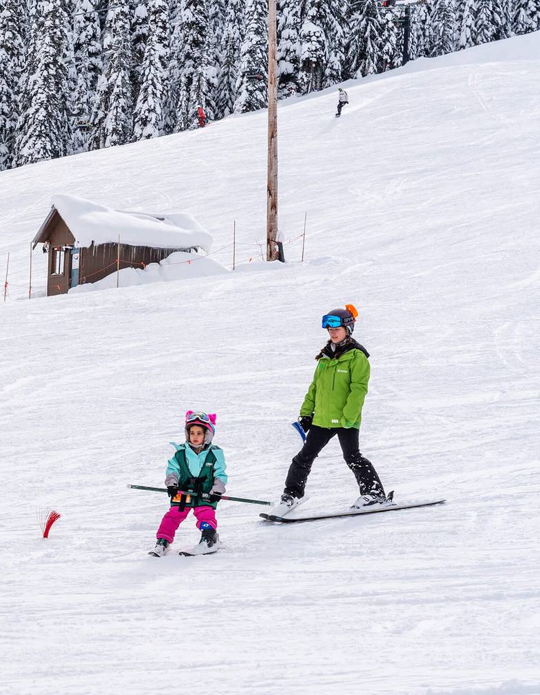 two children age three with instructors on magic carpet terrain