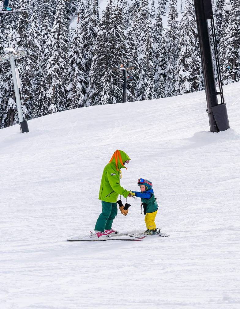 two children age three with instructors on magic carpet terrain