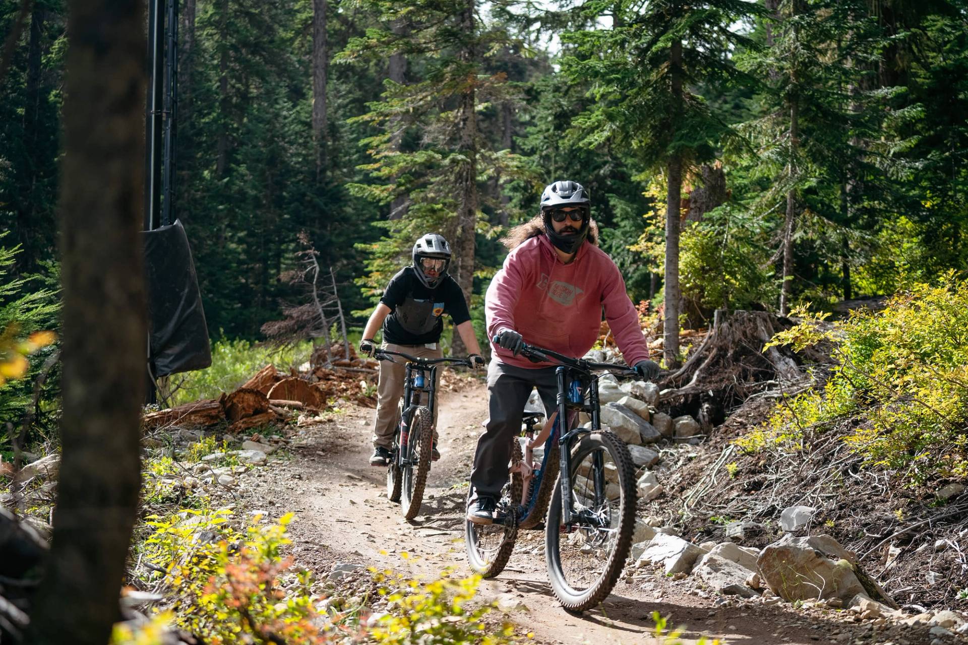 two mountain bikers on rental bikes going down easy trail