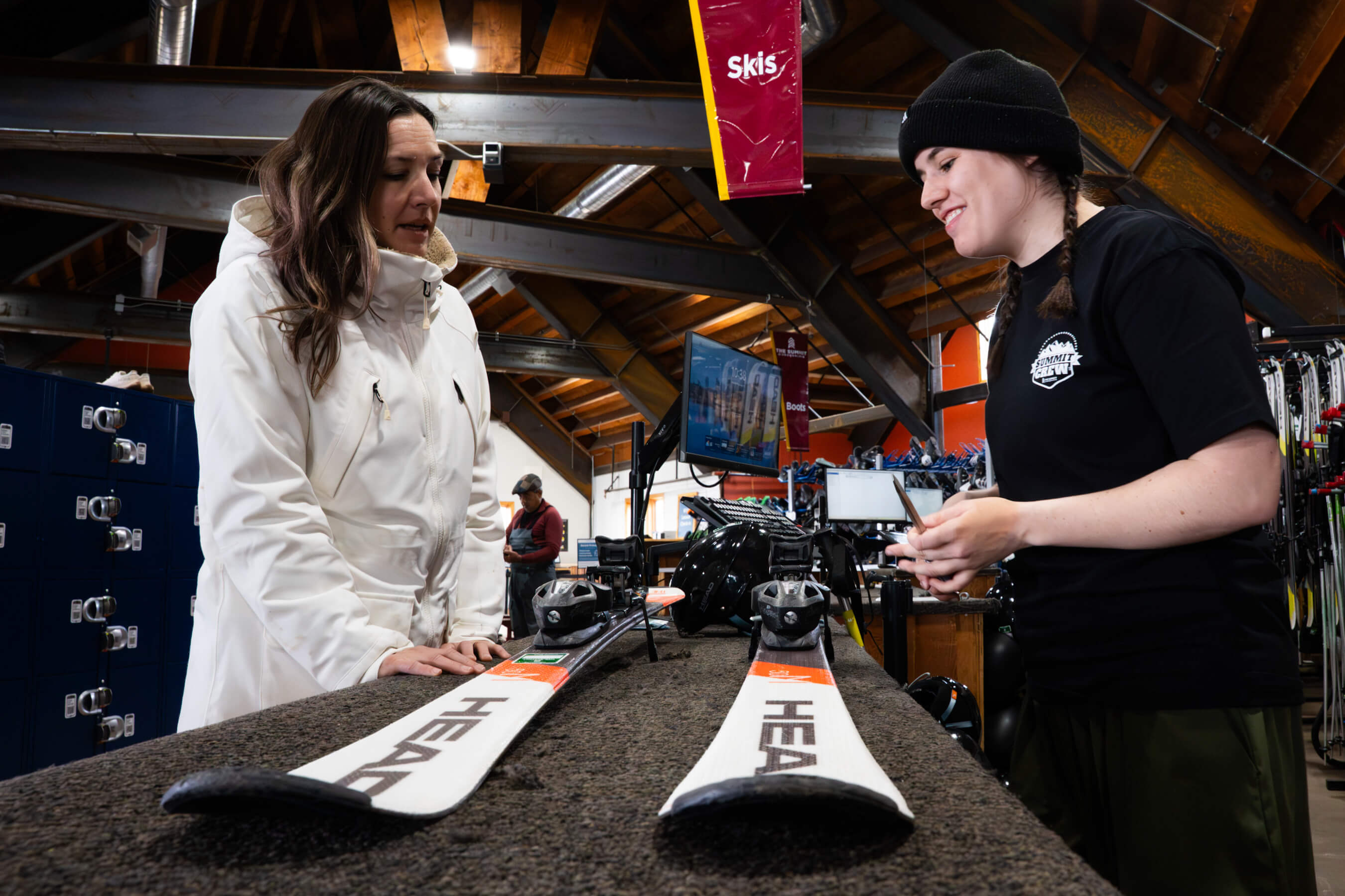 A guest getting their skis from a rental tech