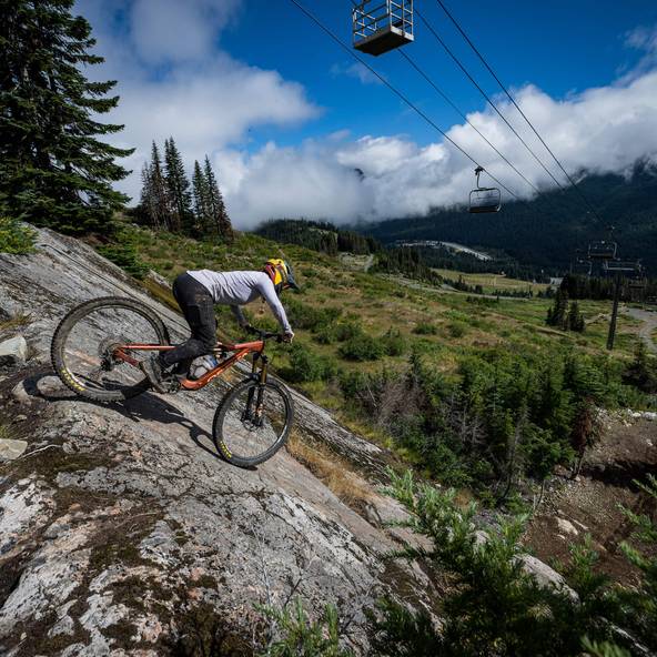 biker on slab with chairlift overhead