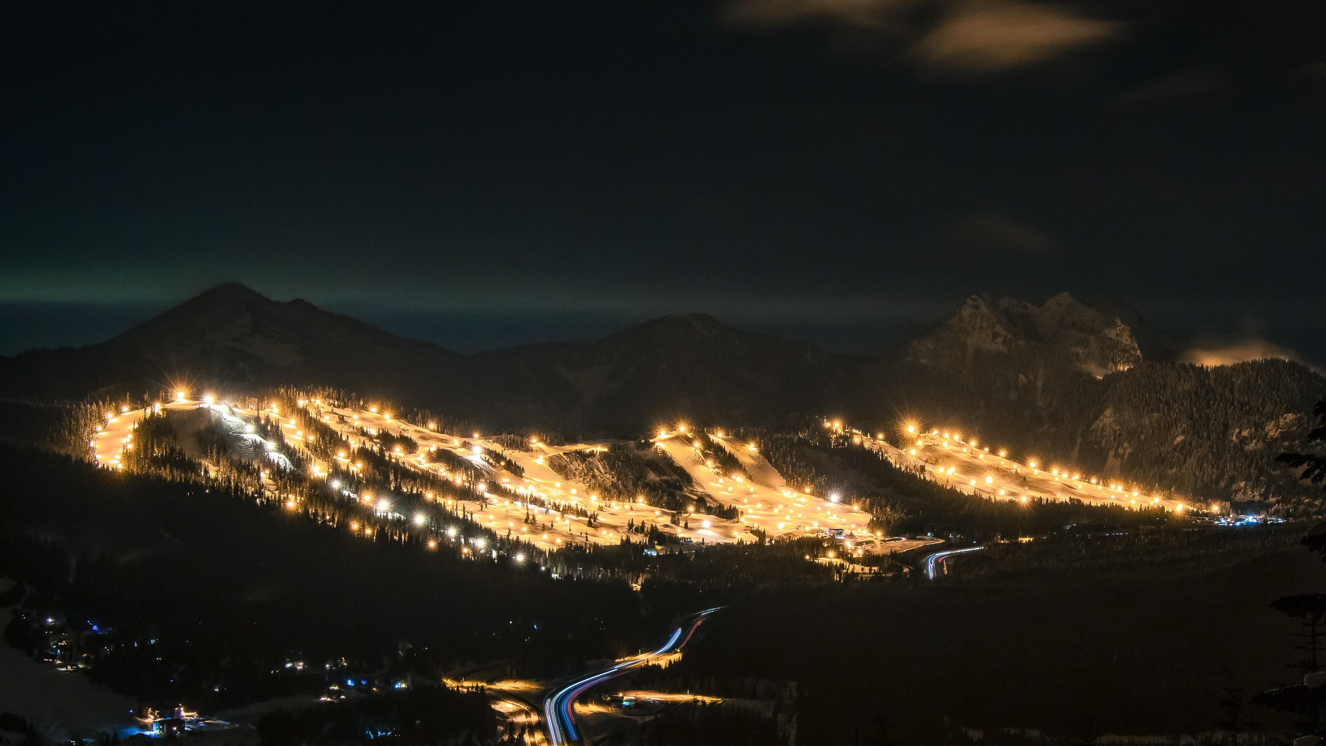 View of Summit Central & West at night with lights across the mountain