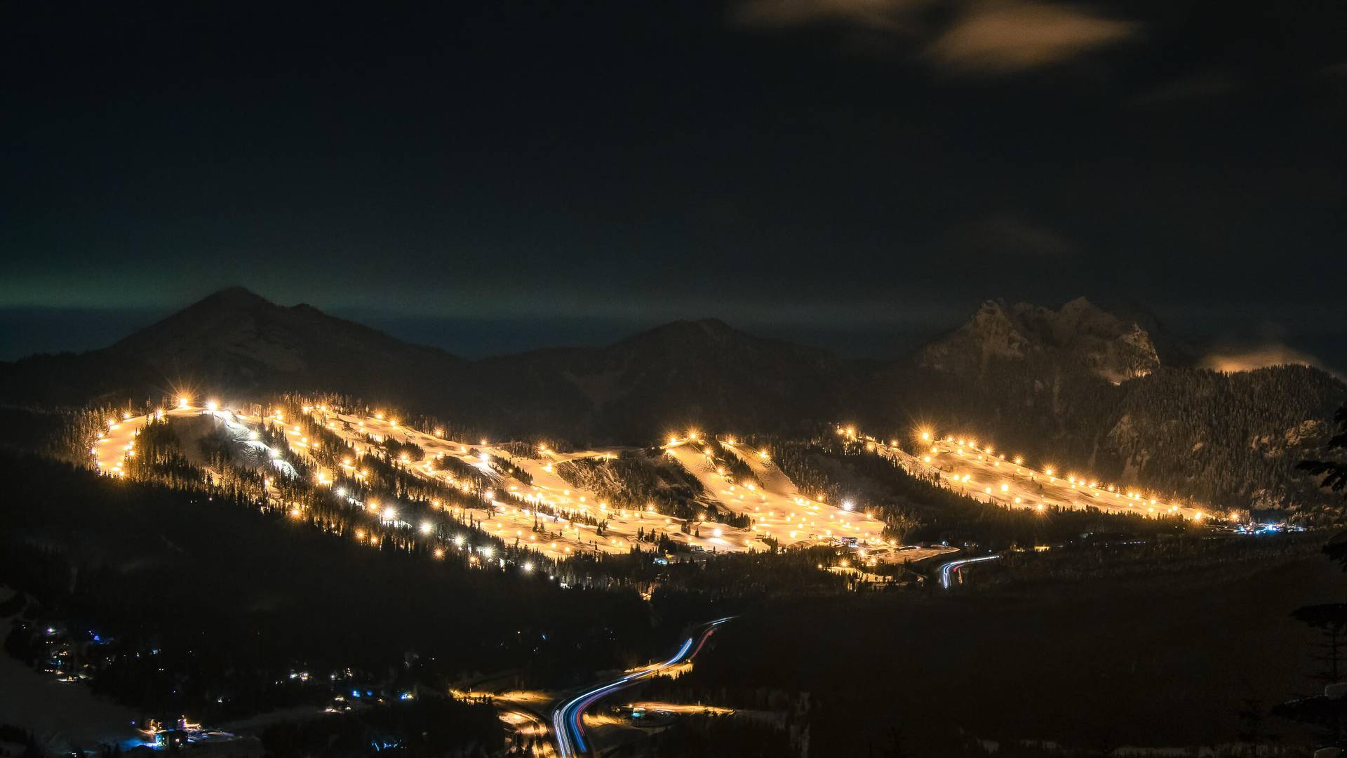 View of Summit Central & West at night with lights across the mountain