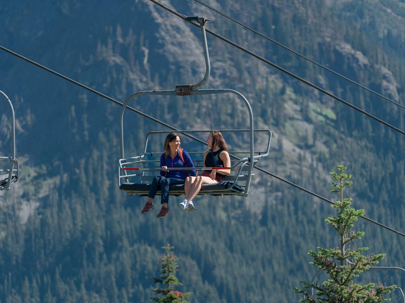 two women on a chairlift in the summer
