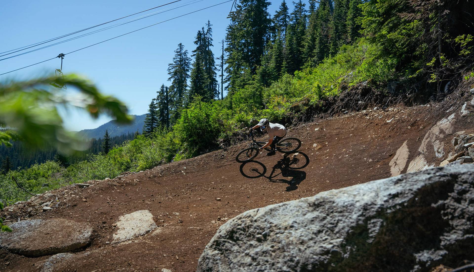 mountain biker in berm below chairlift at The Summit