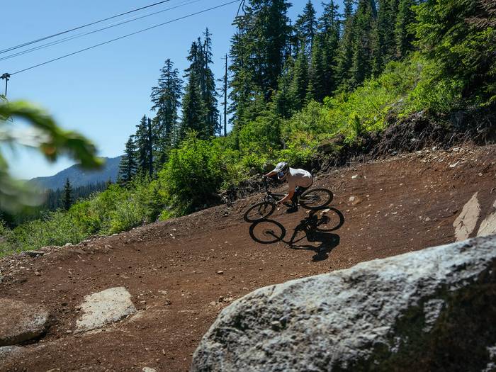 mountain biker in berm below chairlift at The Summit