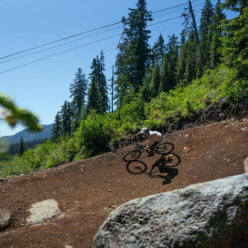 mountain biker in berm below chairlift at The Summit