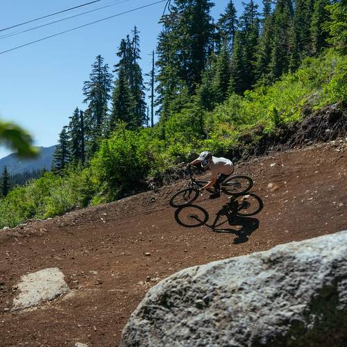 mountain biker in berm below chairlift at The Summit