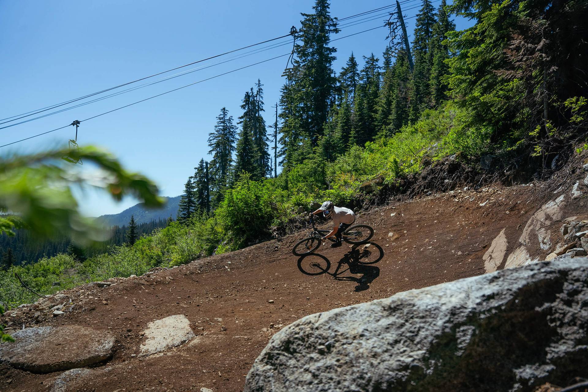 mountain biker in berm below chairlift at The Summit