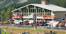Busy plaza for live music at Summit West on a summer evening with scenic views of Guye Peak