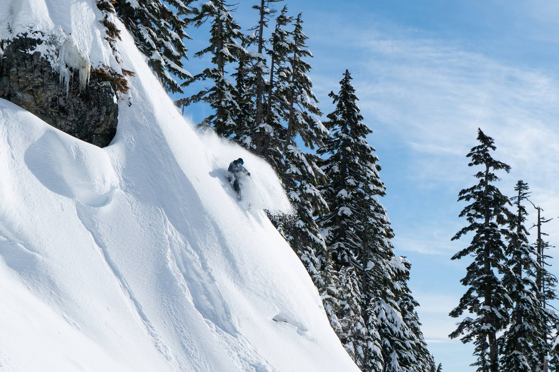 skier making turn on steep slope