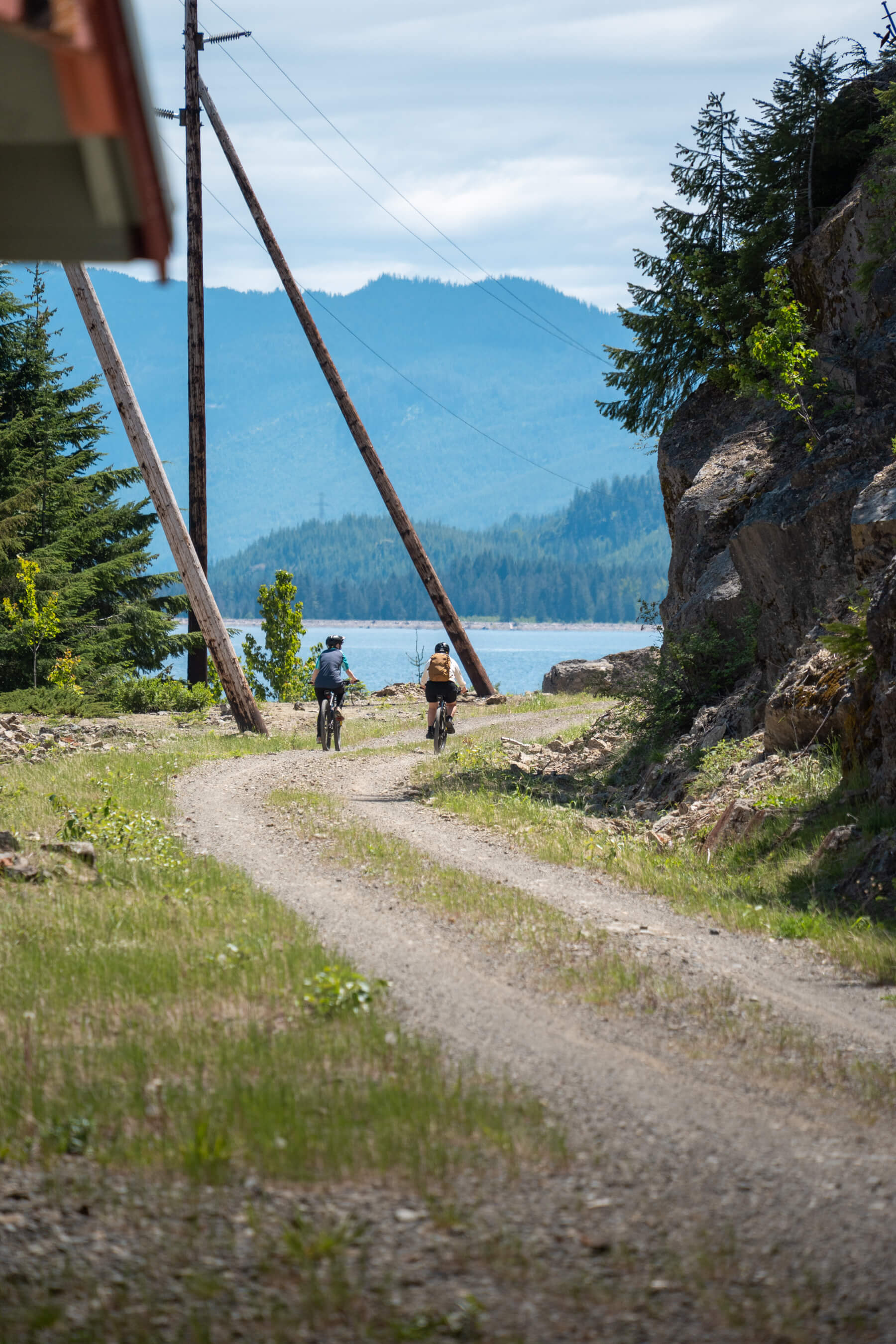 a group of people on bikes riding towards a lake
