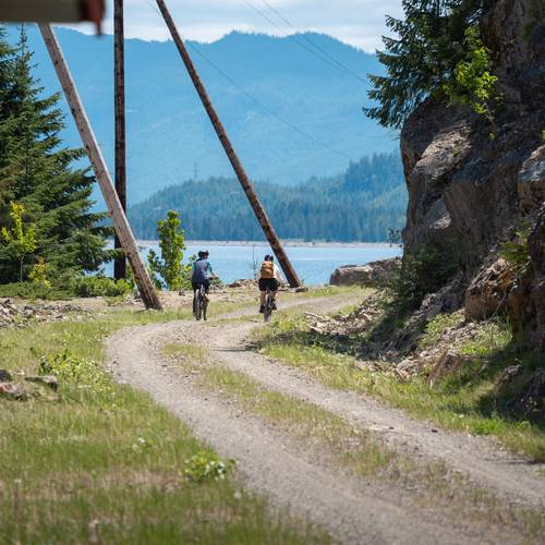 a group of people on bikes riding towards a lake