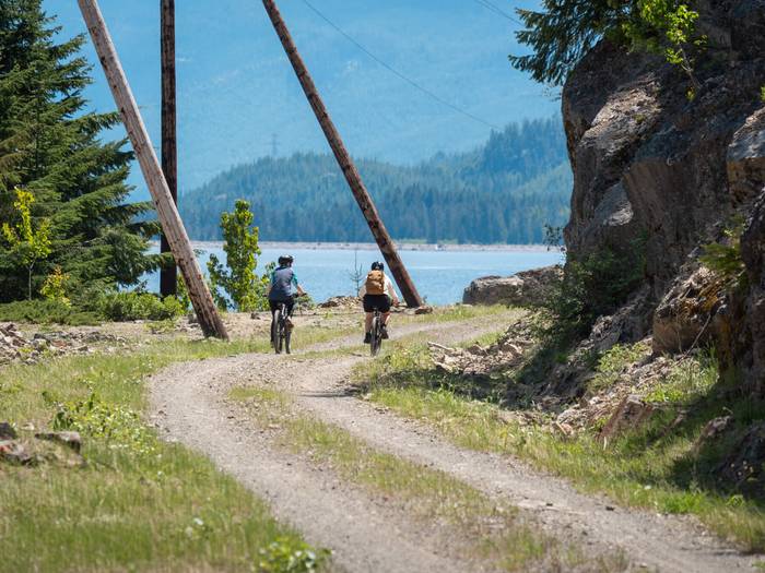 a group of people on bikes riding towards a lake
