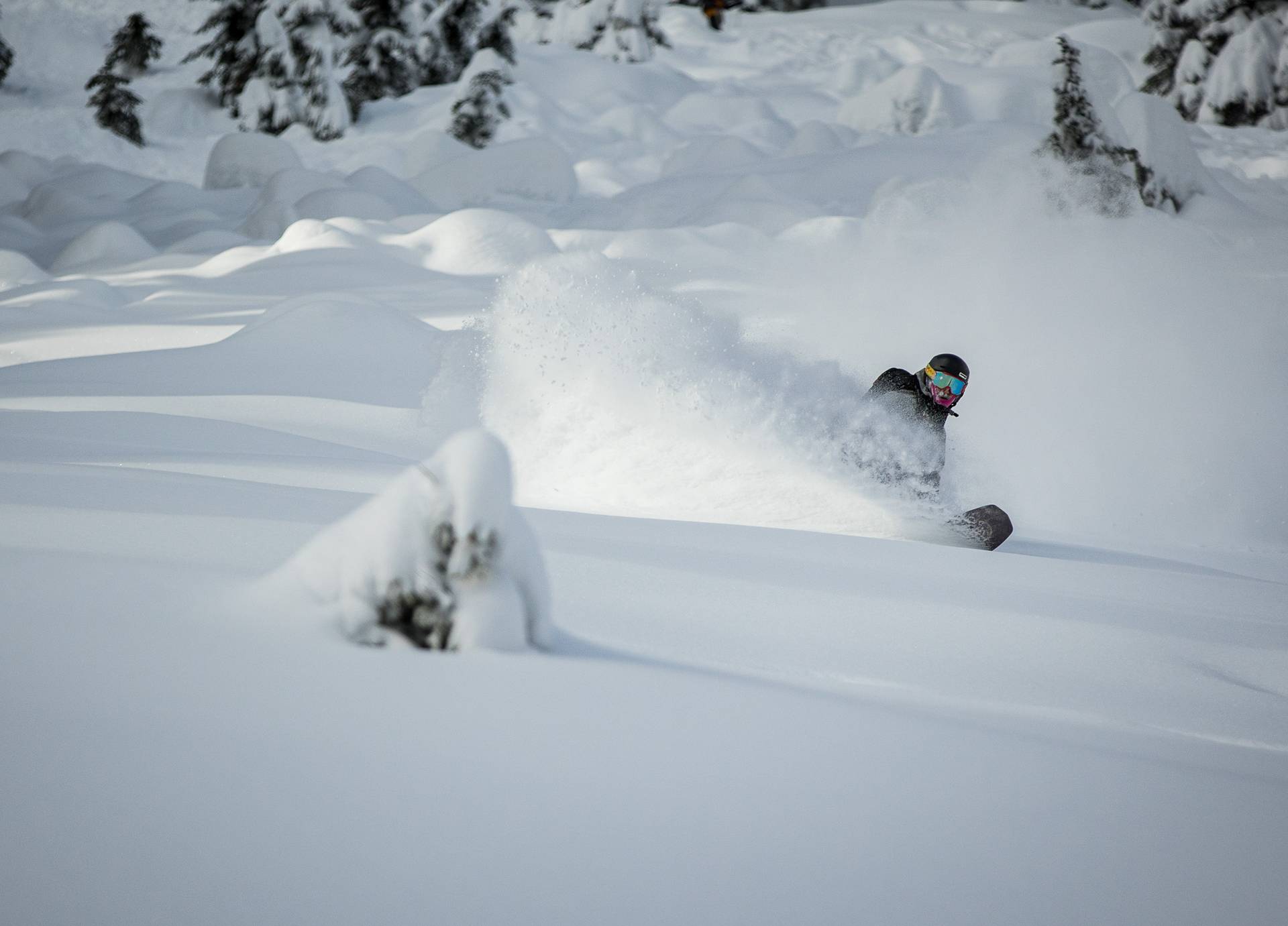 snowboarder powder turn in back bowls