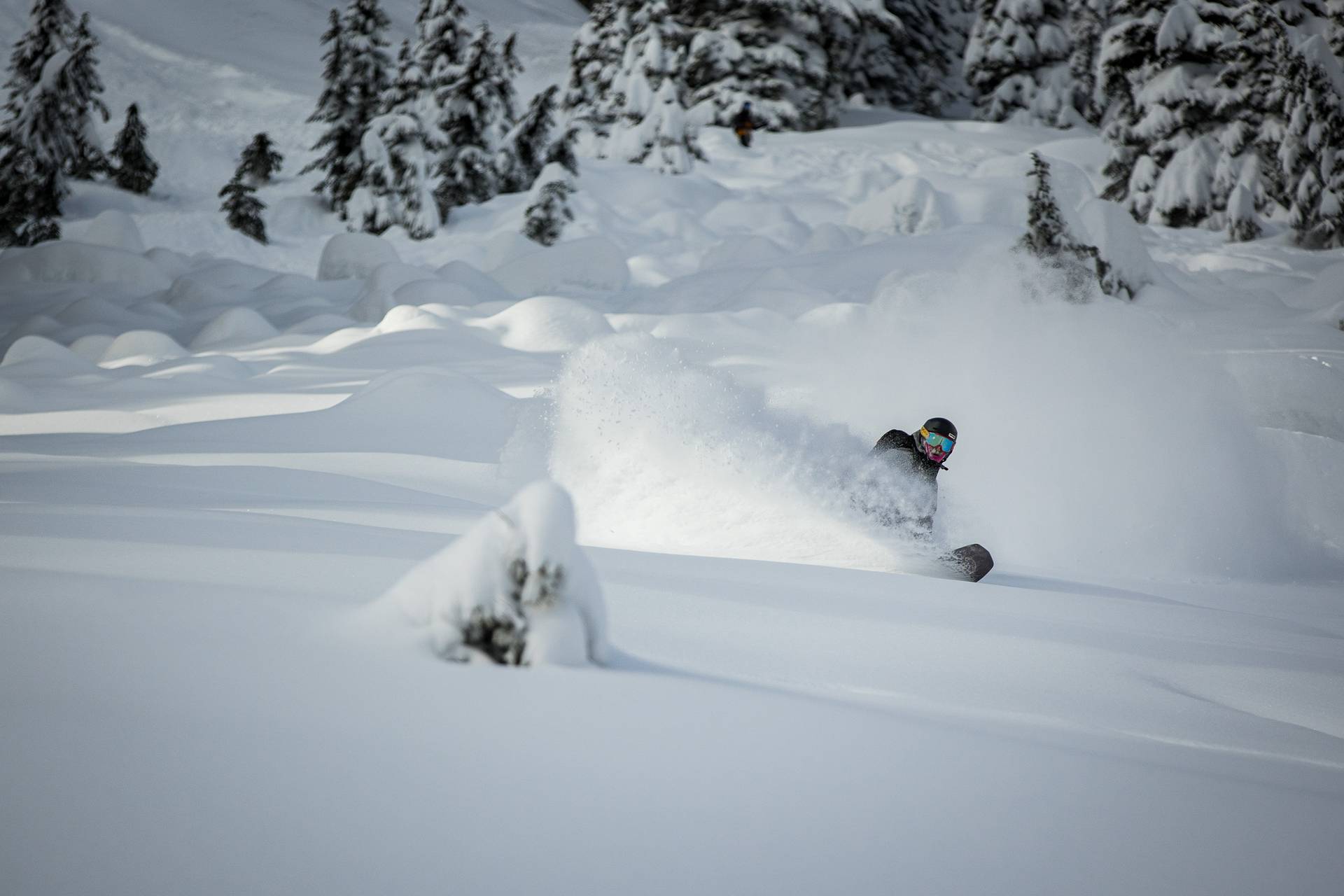 snowboarder turning in deep powder