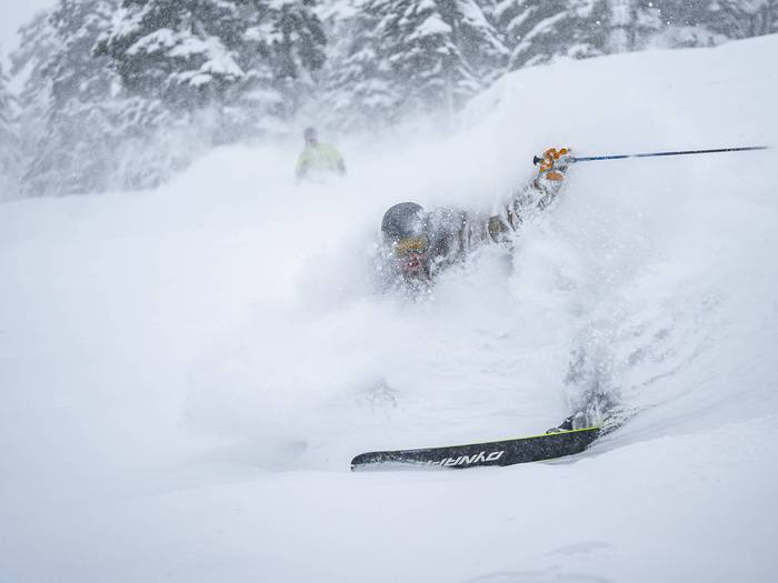 skier in deep powder slashing a turn