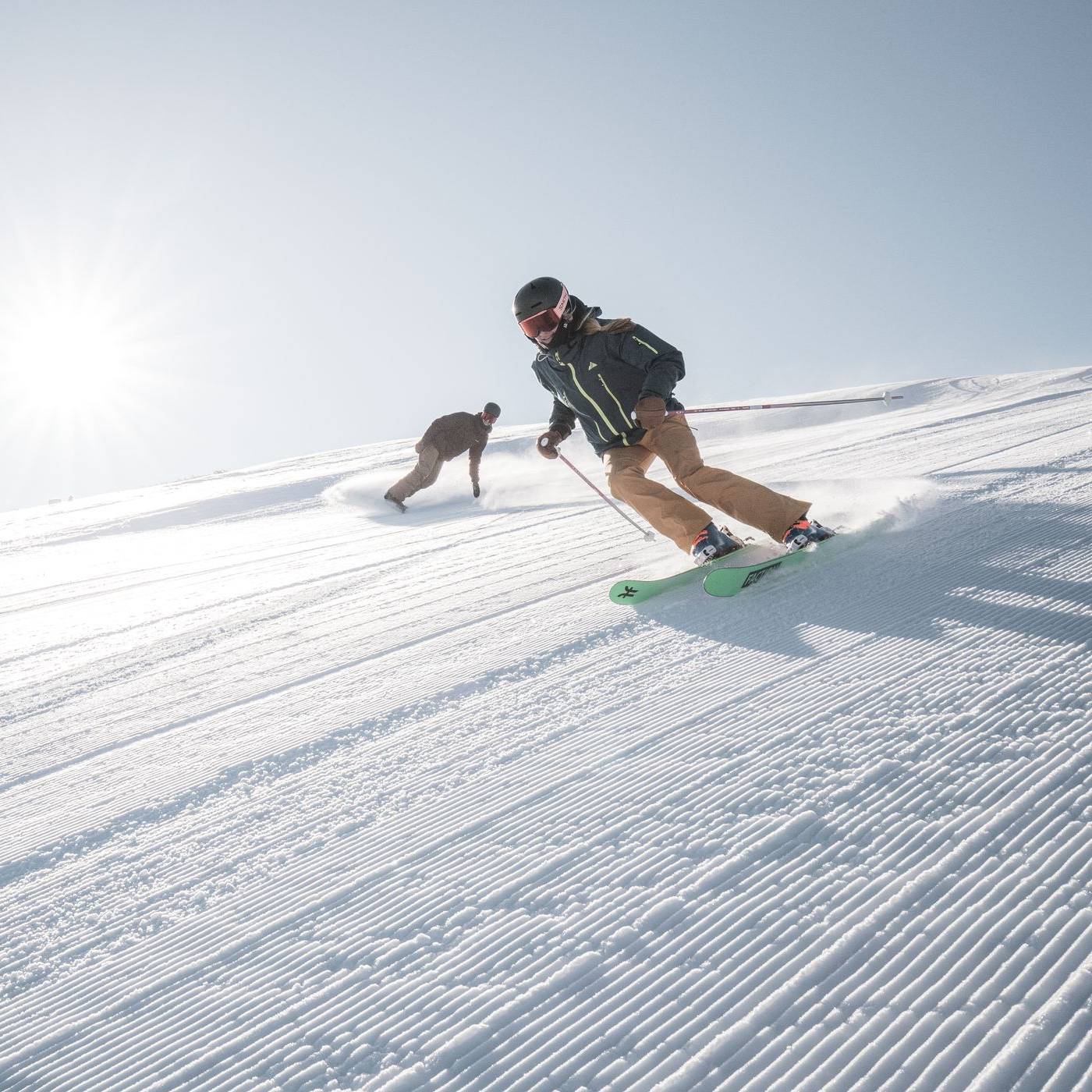 Skier and snowboarder on corduroy