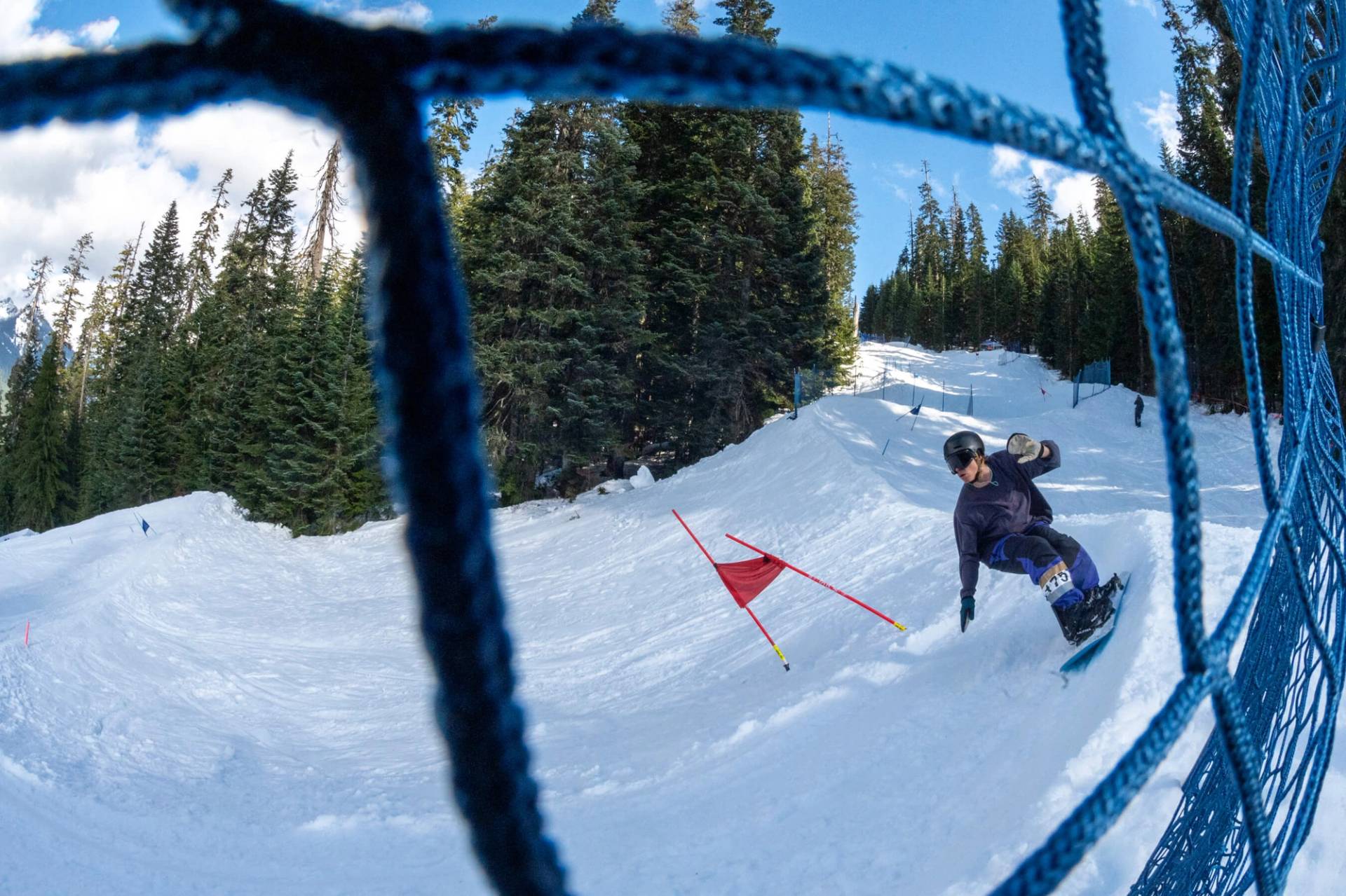 snowboarder rounds turn on banked slalom course