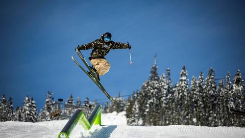 skier hitting rail in terrain park