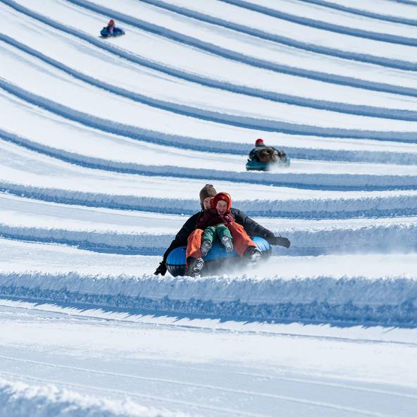Dad and child snow tubing