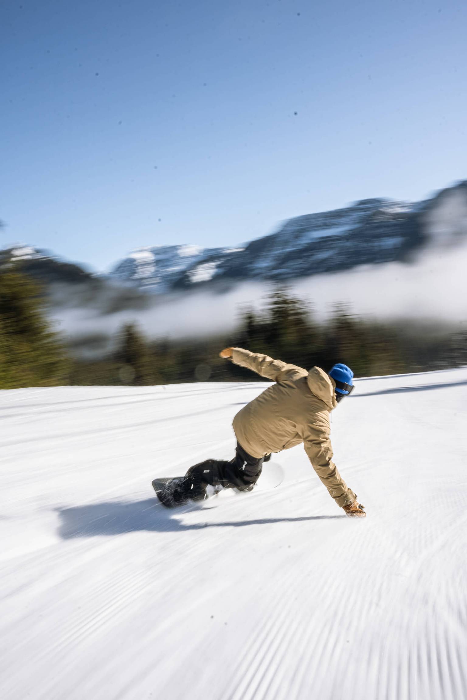 snowboarder carving down hill