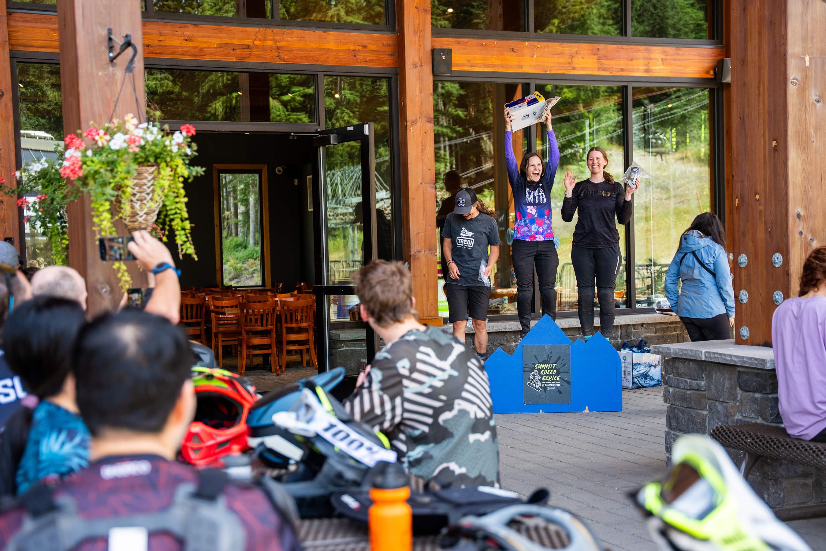 an audience watching women line up on a podium with their prizes