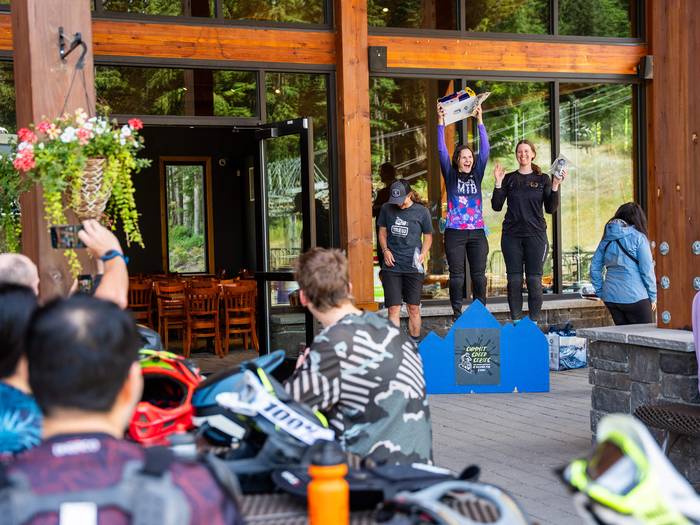 an audience watching women line up on a podium with their prizes