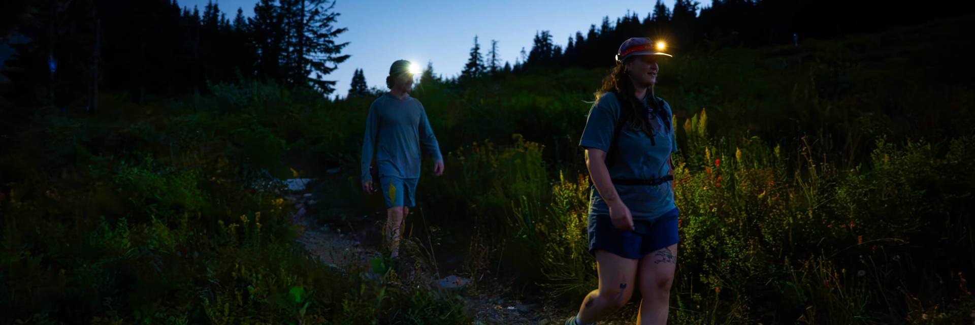 two hikers with headlamps walking on the pacific crest trail
