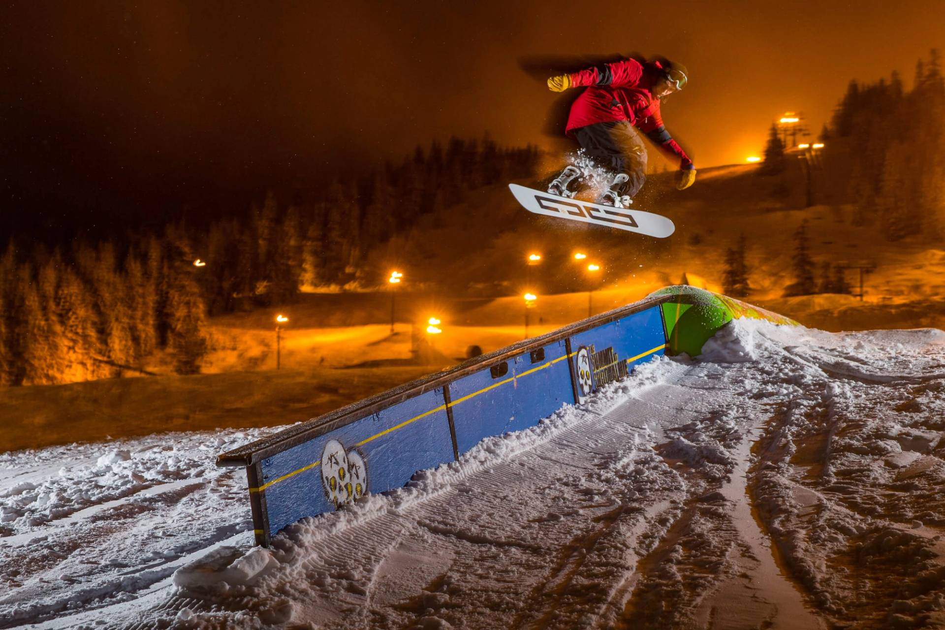 snowboarded at night jumping over rai