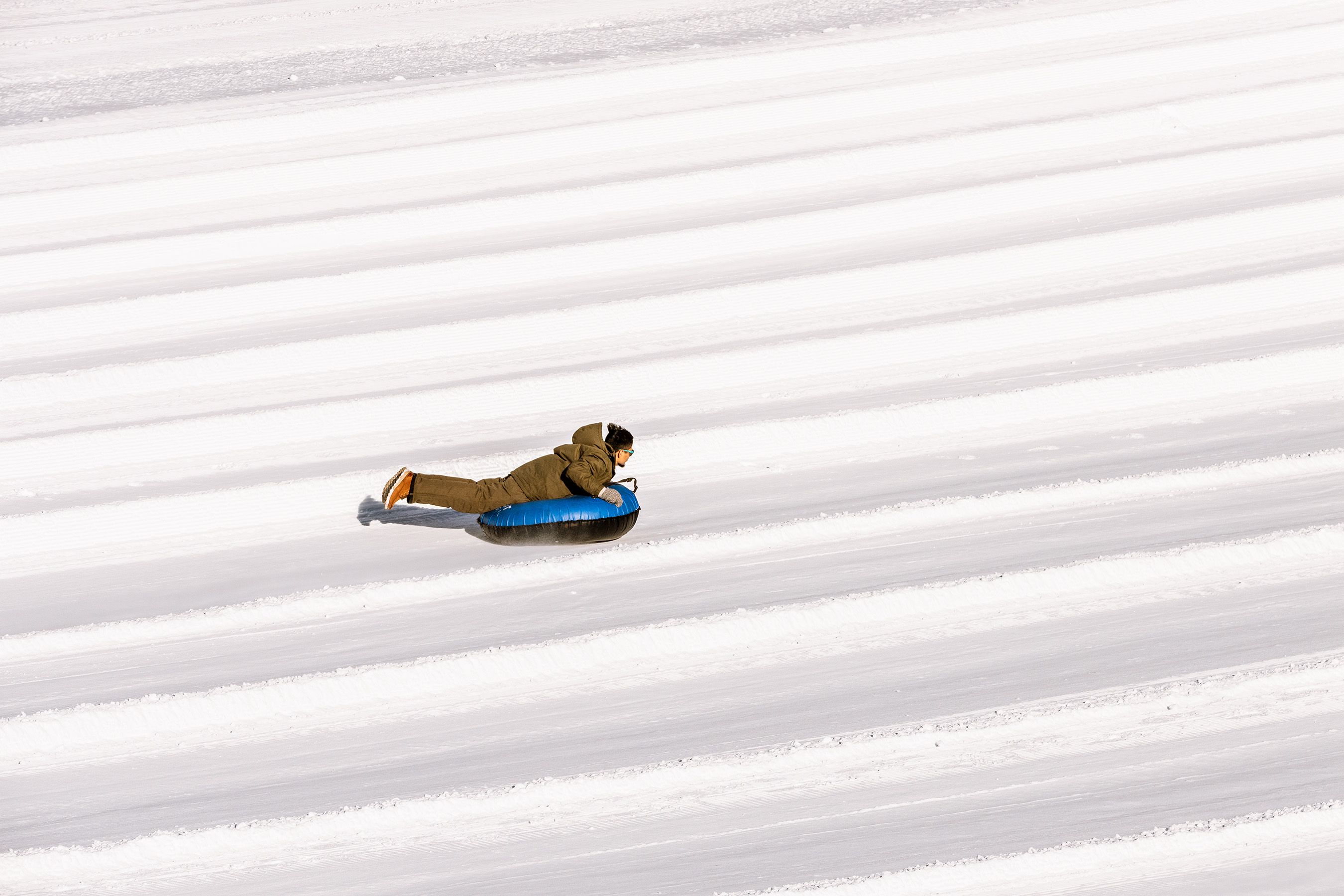 someone riding a snow tube smiling